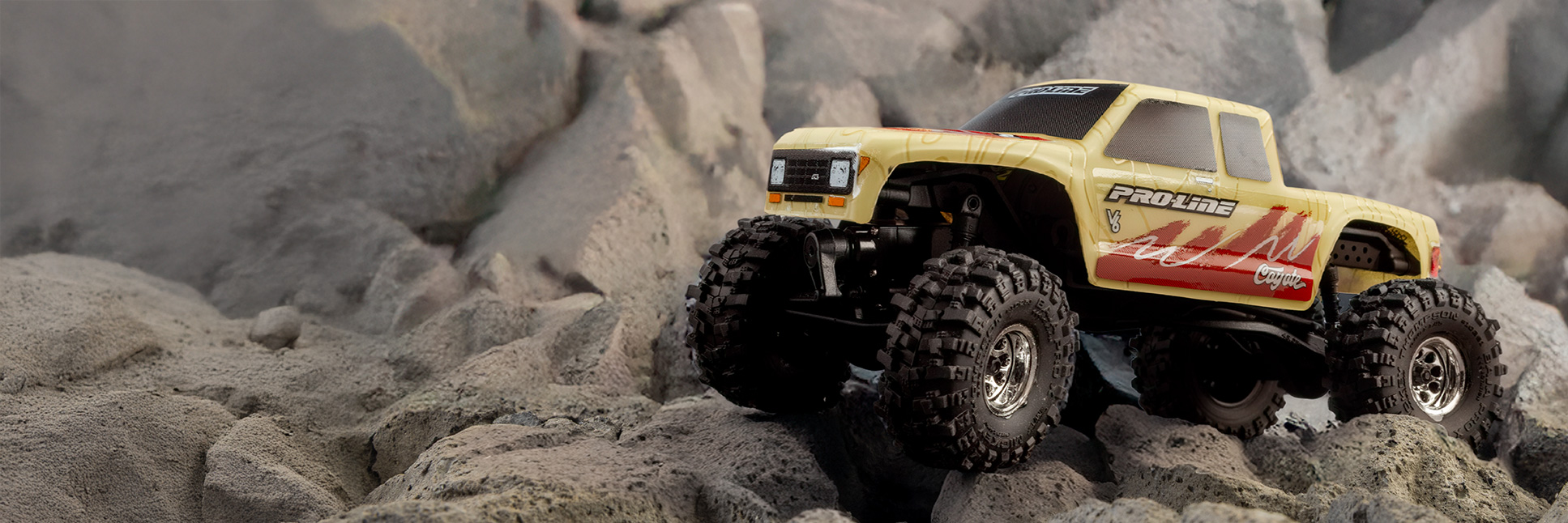 Action shot of the Pro-Line 1/30 Limited Edition Pre-Cut/Pre-Painted Coyote High Performance Tan Topo Body for the Axial SCX30 crawling over rocky terrain Action shot of the Pro-Line 1/30 Limited Edition Pre-Cut/Pre-Painted Coyote High Performance Tan Topo Body for the Axial SCX30 crawling over rocky terrain